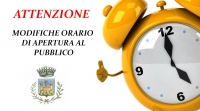 Sveglia gialla sulla destra, a sinistra dicitura "attenzione modifiche orario di apertura al pubblico"